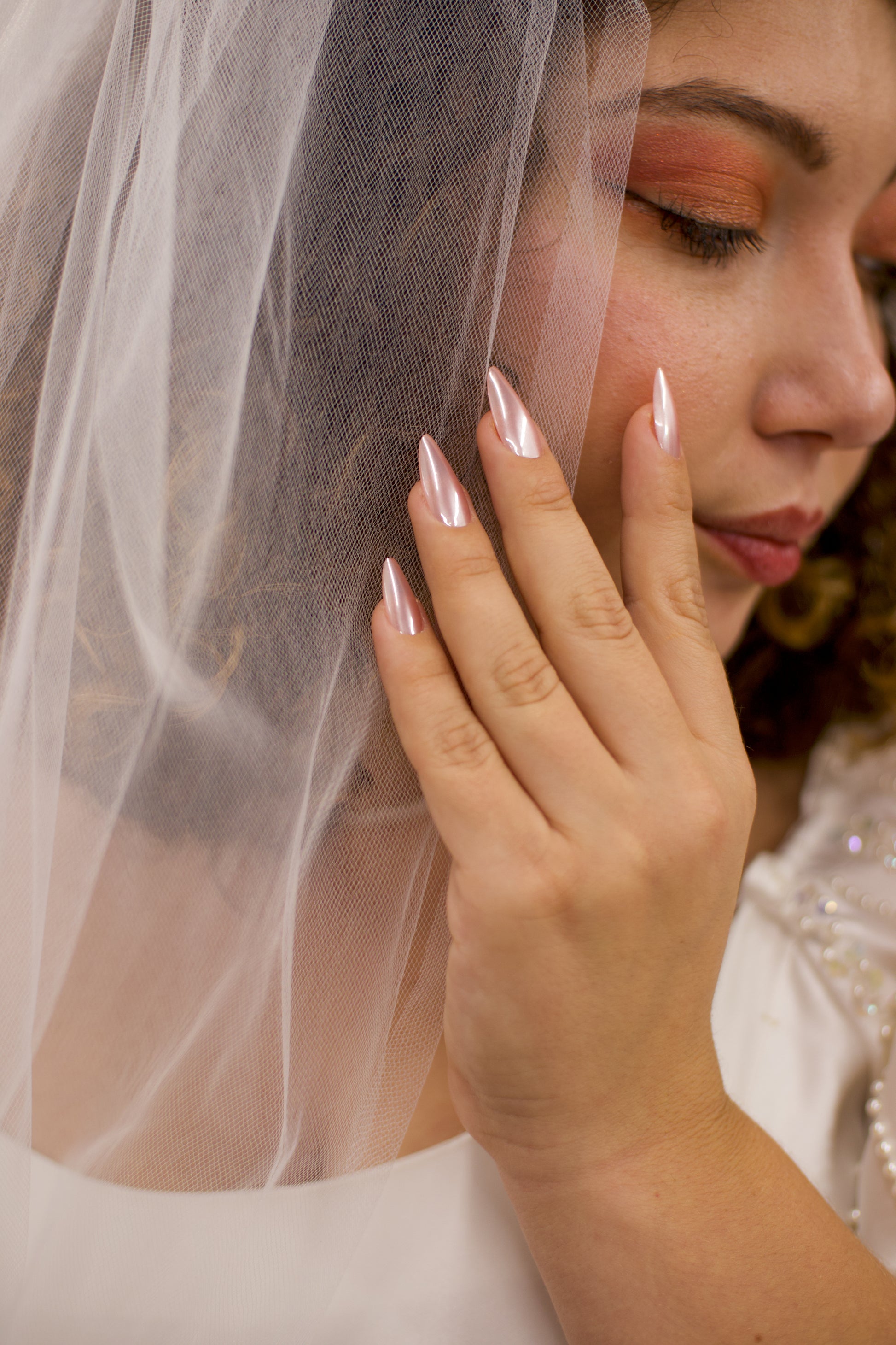 Close-up of a bride with a veil and orange makeup