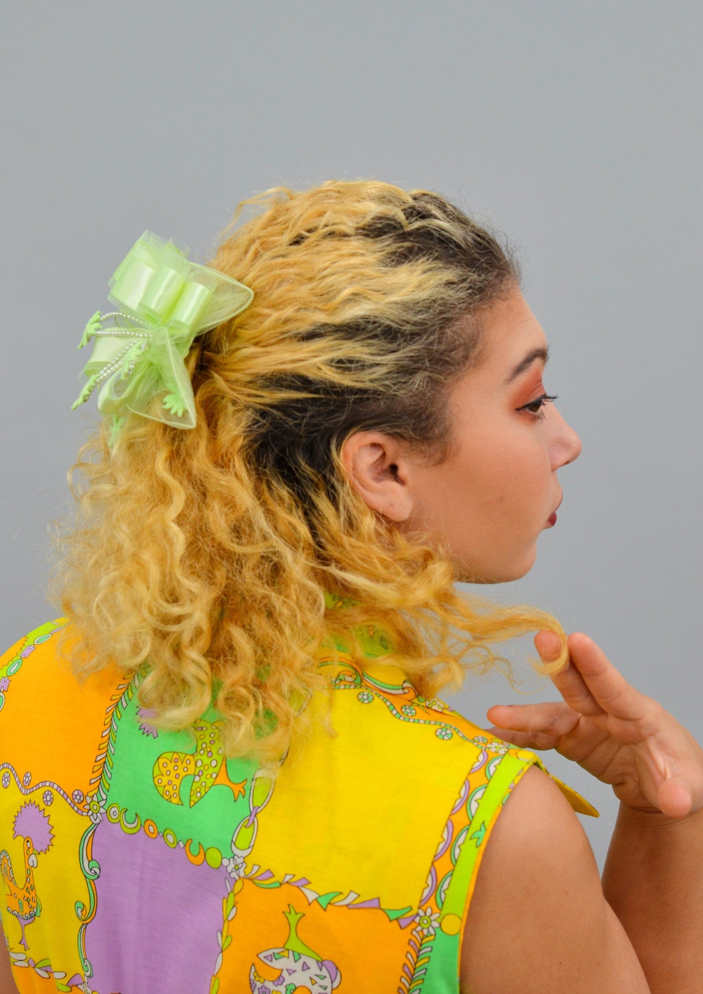 woman wearing a large lime green ribbon lace hair piece