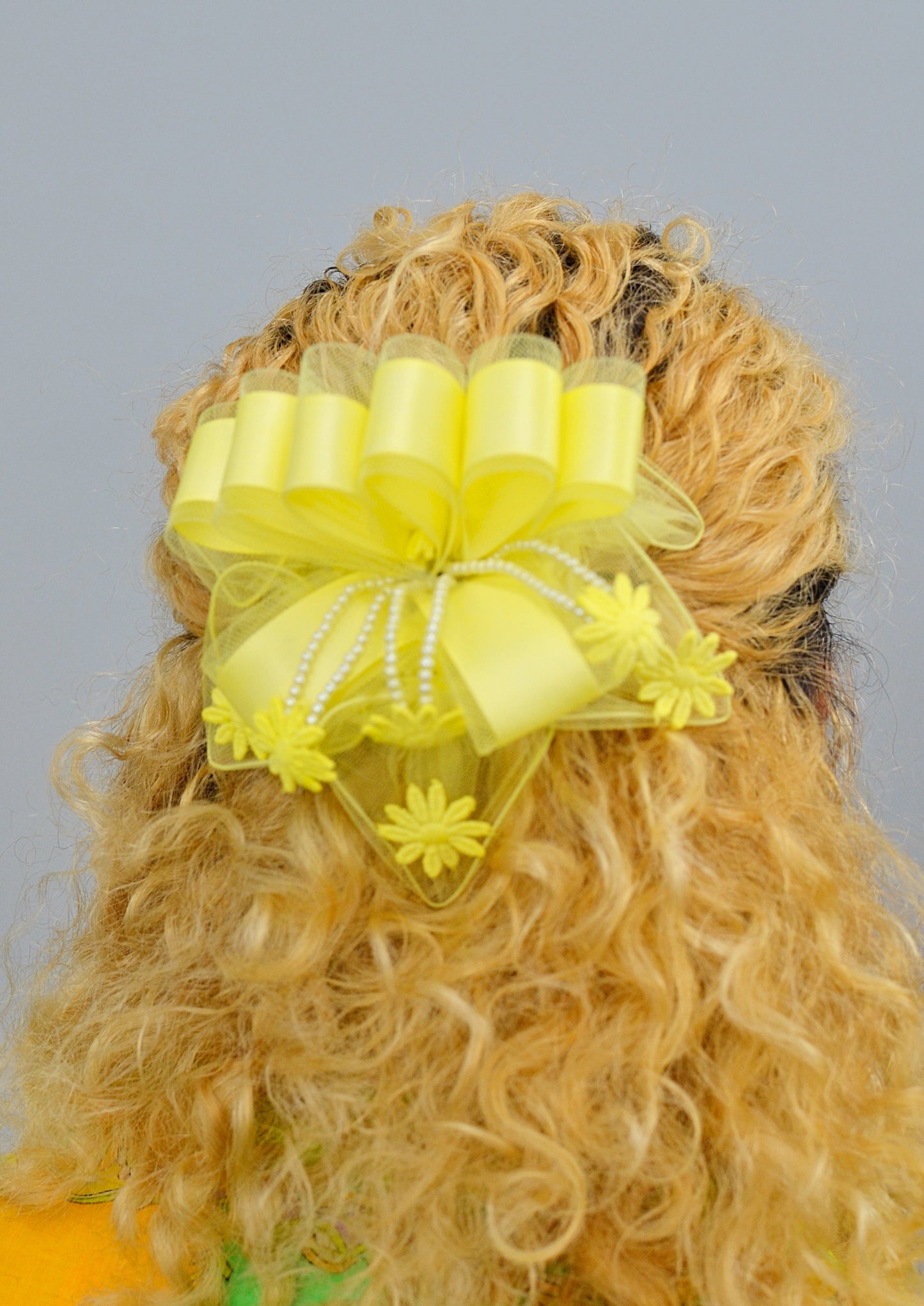 woman wearing a large yellow ribbon lace hair piece