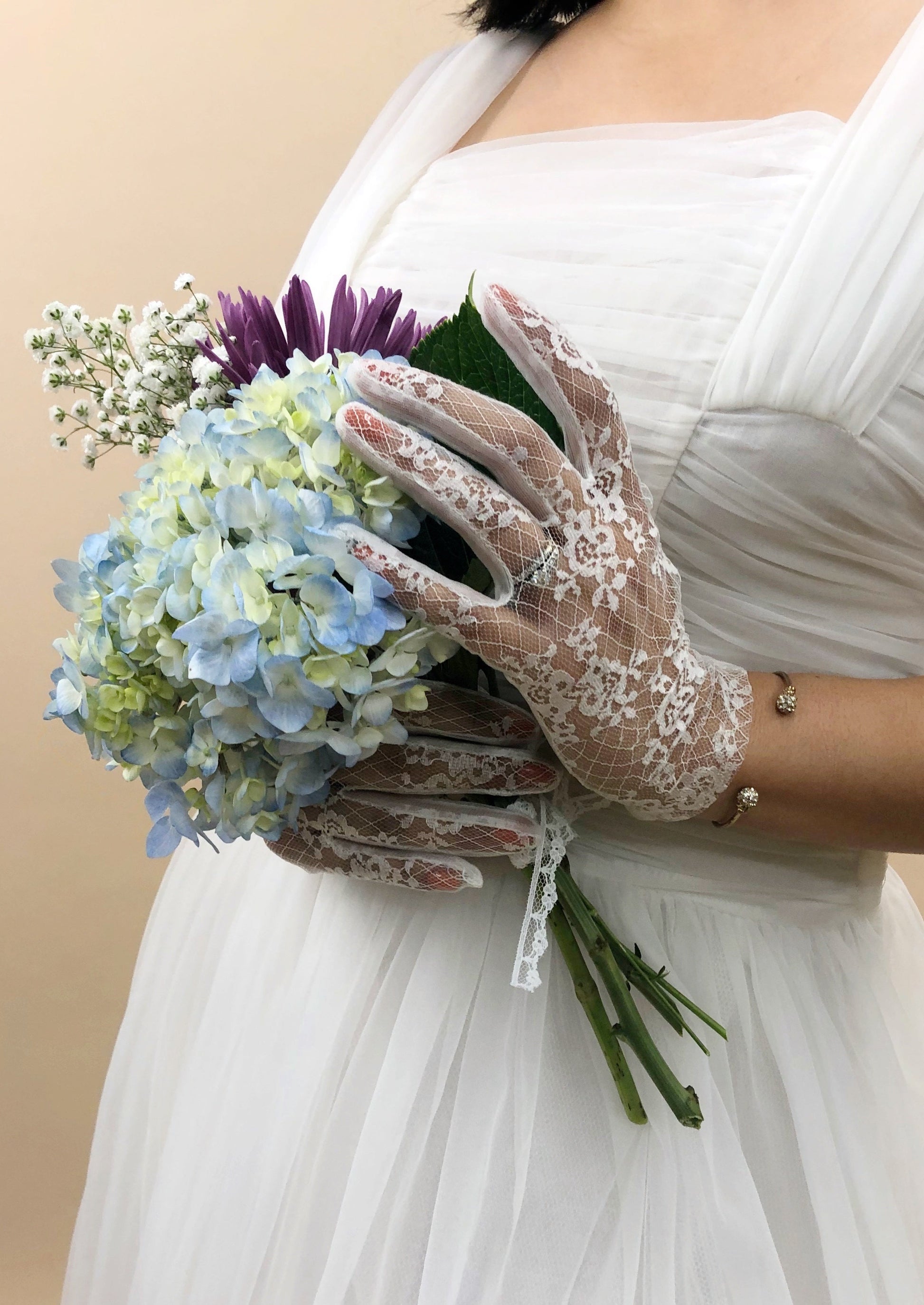 hands wearing gloves holding flower bouquet