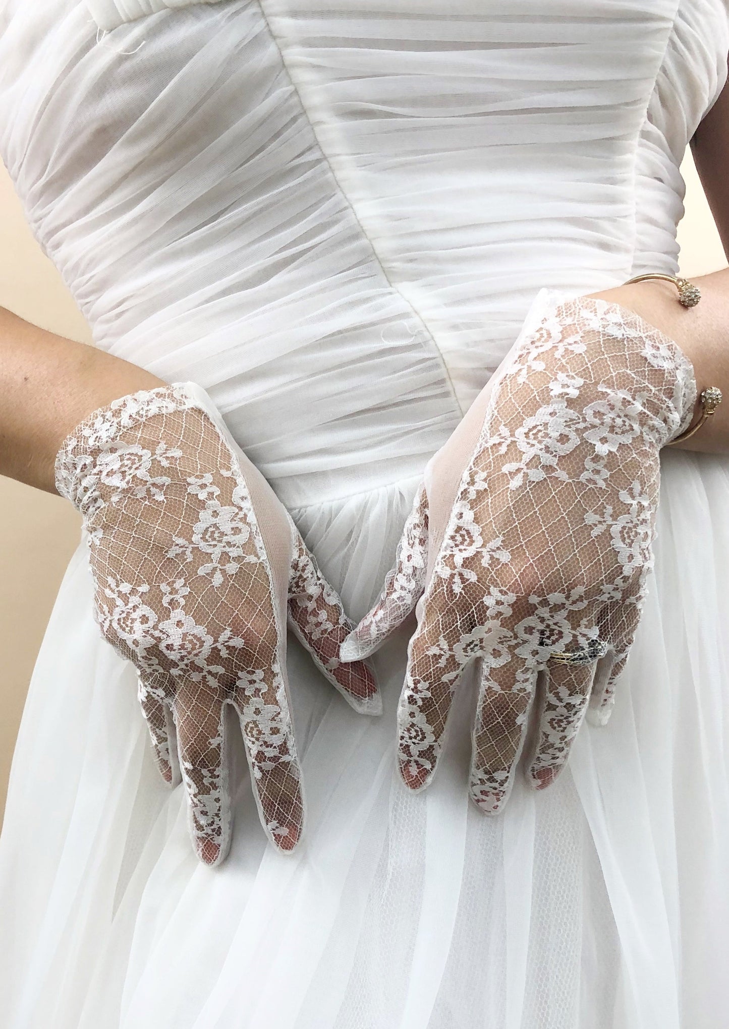 Zoomed in photo of sheer gloves on top of the white chiffon dress