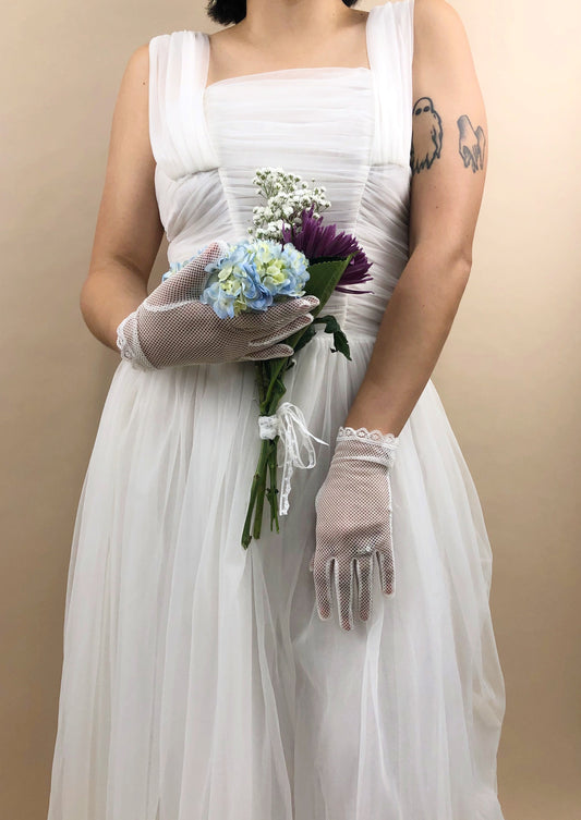 woman in a white chiffon gown with the Florence mesh net gloves holding a floral bouquet